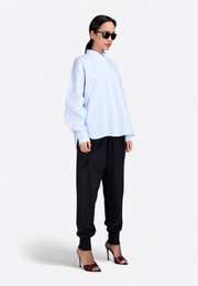 Model wearing classic long-sleeved light blue shirt, front-side pose – East Vibe